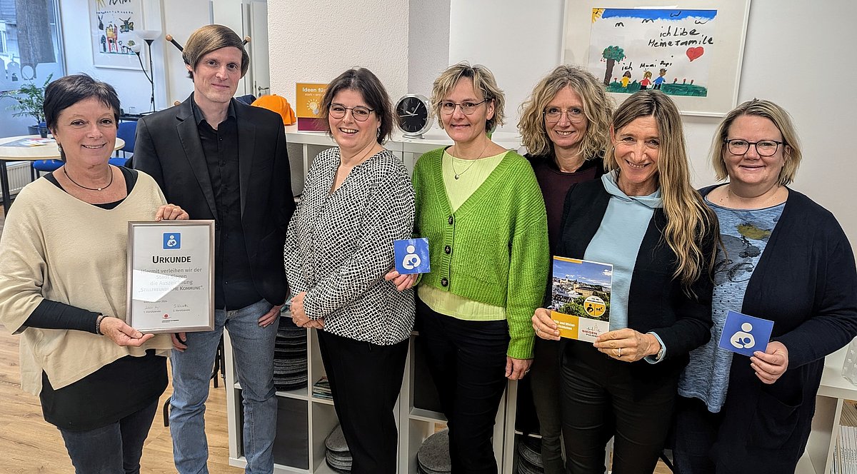 Die Kreisvorsitzende der Hebammen in den Kreisen Siegen-Wittgenstein und Olpe, Andrea Winter (3. von links), überreichte im städtischen Familienbüro das Zertifikat „stillfreundliche Kommune“. (Foto: Stadt Siegen)