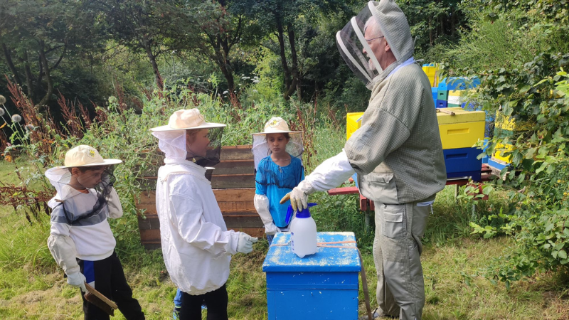 Hobbyimker Andreas Haupt führte die Kinder am Bienenstock in die Welt der Honigbienen ein. (Foto: Stadt Siegen)