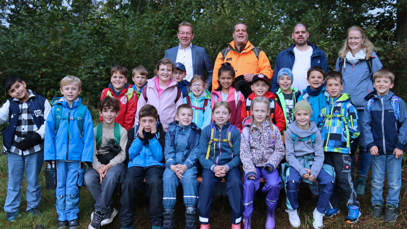 (v.l.) Bürgermeister Steffen Mues, Leiter der Stabsstelle Klimaschutz Lars Ole Daub und Umweltpädagoge Daniel Rath zusammen mit den Grundschülern der Sonnenhangschule. (Foto: Stadt Siegen)